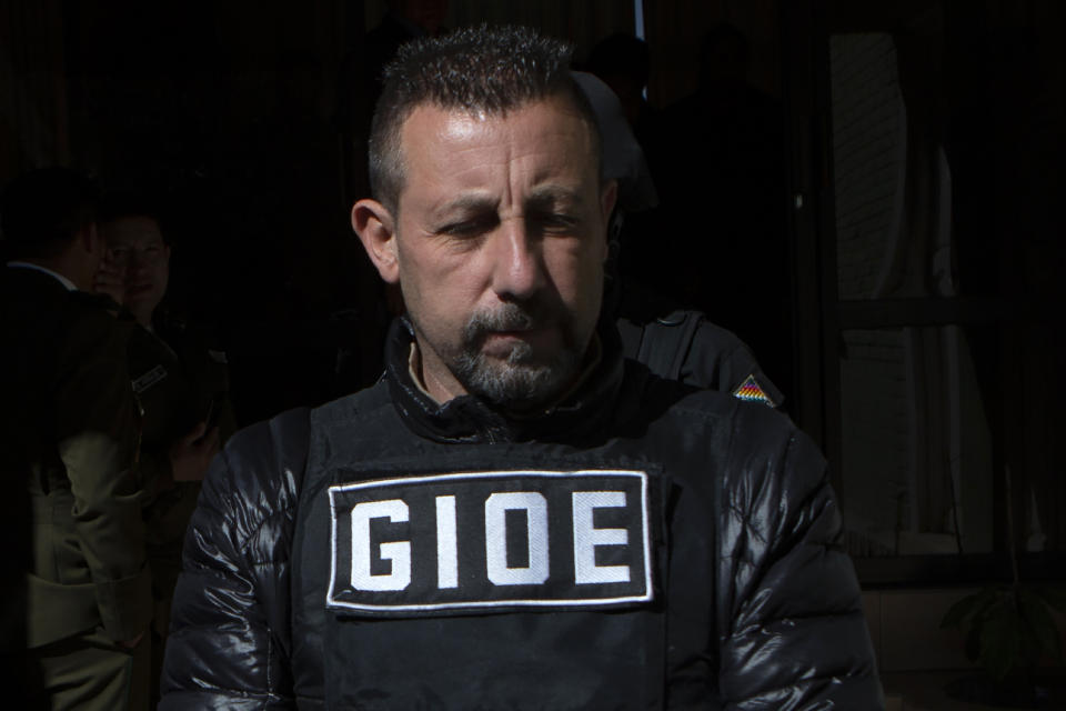 Alleged drug kingpin Paolo Lumia, wearing a bulletproof vest, is escorted to a waiting vehicle by anti-drug officers, after a media presentation in La Paz, Bolivia, Thursday, July 4, 2019. Authorities in Bolivia arrested Lumia in the Bolivian city of Cochabamba on Wednesday night. There is an international arrest warrant out for the Italian citizen. (AP Photo/Juan Karita)