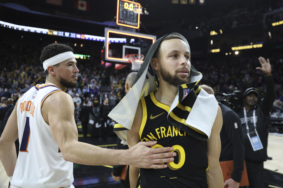 Golden State Warriors guard Stephen Curry, front right,is congratulated by Phoenix Suns guard Devin Booker (1) after an NBA basketball game in San Francisco, Saturday, Feb. 10, 2024. (AP Photo/Jed Jacobsohn)