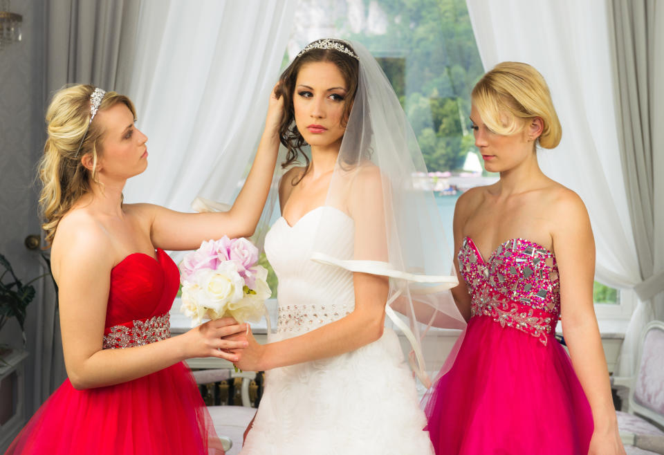 Two bridesmaids helping an angry bride