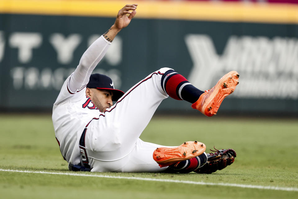 Atlanta Braves left fielder Eddie Rosario slides to catch a fly ball for the out on New York Mets' Brandon Nimmo during the first inning of a baseball game, Tuesday, Aug. 22, 2023, in Atlanta. (AP Photo/Butch Dill)