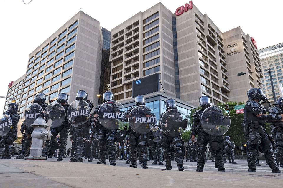 Police stand guard around the CNN Center and Centennial Olympic park as protests continue over the death of George Floyd, Saturday, May 30, 2020, in Atlanta. Protests were held in U.S. cities over the death of Floyd, a black man who died after being restrained by Minneapolis police officers on May 25. (Ben Gray/Atlanta Journal-Constitution via AP)