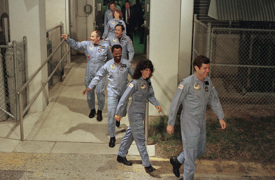 The crew for the Space Shuttle Challenger flight 51-L leaves their quarters for the launch pad, Jan. 27, 1986, at the Kennedy Space Center in Florida. Front to back are Commander Francis Scobee, Mission Spl. Judith Resnik, Mission Spl. Ronald McNair, Payload Spl. Gregory Jarvis, Mission Spl. Ellison Onizuka, teacher Christa McAuliffe, and pilot Michael Smith. (AP Photo/Steve Helber)