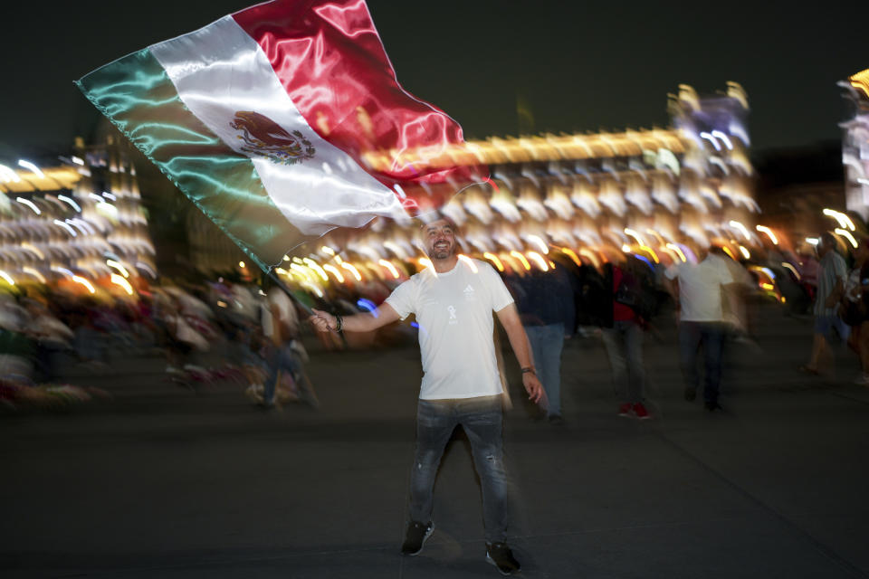 Un seguidor de la candidata oficialista Claudia Sheinbaum ondea una bandera mexicana tras el cierre de urnas en las elecciones generales en el Zócalo, en la principal plaza de Ciudad de México, el domingo 2 de junio de 2024. (AP Foto/Marco Ugarte)