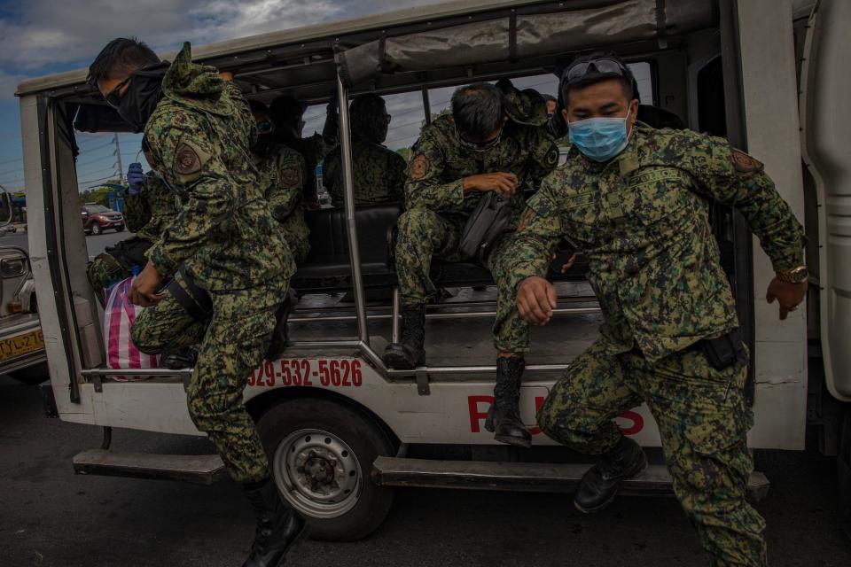 Filipino policemen wearing facemasks man a checkpoint as authorities begin implementing lockdown measures on March 16, 2020 in Las Pinas, Metro Manila, Philippines.