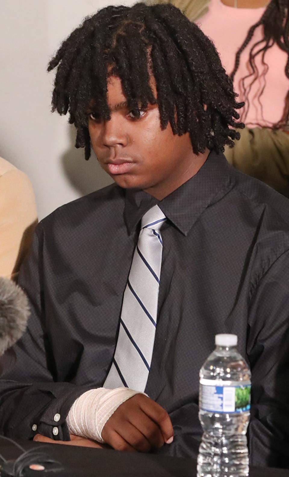 Tavion Koonce-Williams, the 15-year-old shot by an Akron police officer on April 1, listens to his attorney, Imokhai Okolo address the media during an April 12 press conference at 8 Point Hall in Akron.