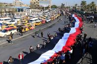 University students carry an Iraqi flag, during ongoing anti-government protests in Baghdad