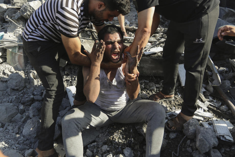 Palestinians comfort a crying man after losing relatives under the rubble of a destroyed house following an Israeli airstrike in Gaza City, Saturday, Nov. 4, 2023. (AP Photo/Abed Khaled)