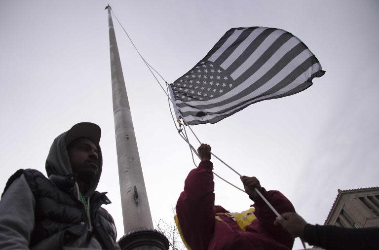 Demonstrators raise a black and white US Flag, believed to be a call for change and a symbol of freedom, as they protest the death of Freddie Gray, an African American man who died in police custody, in Baltimore, Maryland, April 25, 2015