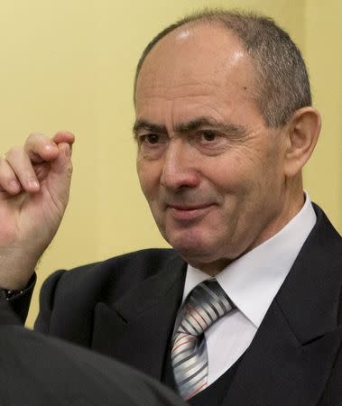 Zdravko Tolimir (R), a former high-ranking Bosnian Serb army officer charged with crimes including genocide in the 1995 Srebrenica massacre, gestures as he waits for the the Yugoslav war crimes tribunal to deliver its judgment in The Hague, in this file picture taken December 12, 2012. REUTERS/Peter Dejong/Pool/Files