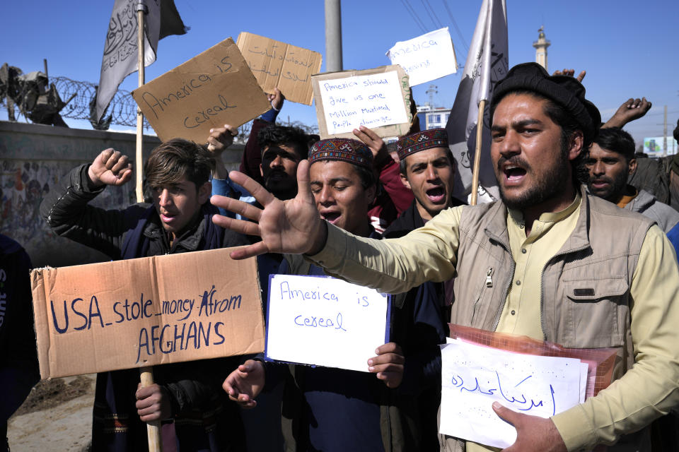 Afghan protesters hold placards and shout slogans against U.S. during a protest condemning President Joe Biden's decision, in Kabul, Afghanistan, Saturday, Feb. 12, 2022. President Biden signed an executive order, Friday, Feb. 11, to create a pathway to split $7 billion in Afghan assets frozen in the U.S. to fund humanitarian relief in Afghanistan and to create a trust fund to compensate Sept. 11 victims. (AP Photo/Hussein Malla)