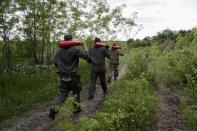 Service members of pro-Russian troops carry leaflet shells in the Luhansk region