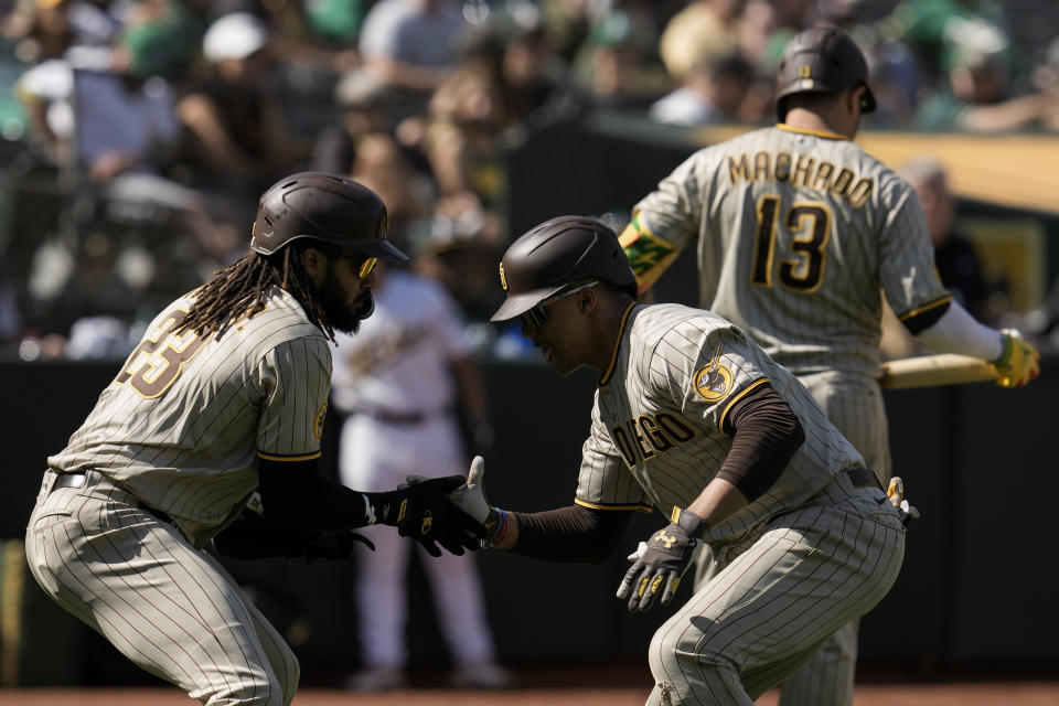 San Diego Padres' Juan Soto, right, celebrates with Fernando Tatis Jr., left, after hitting a two-run home run against the Oakland Athletics during the seventh inning of a baseball game, Sunday, Sept. 17, 2023, in Oakland, Calif. (AP Photo/Godofredo A. Vásquez)