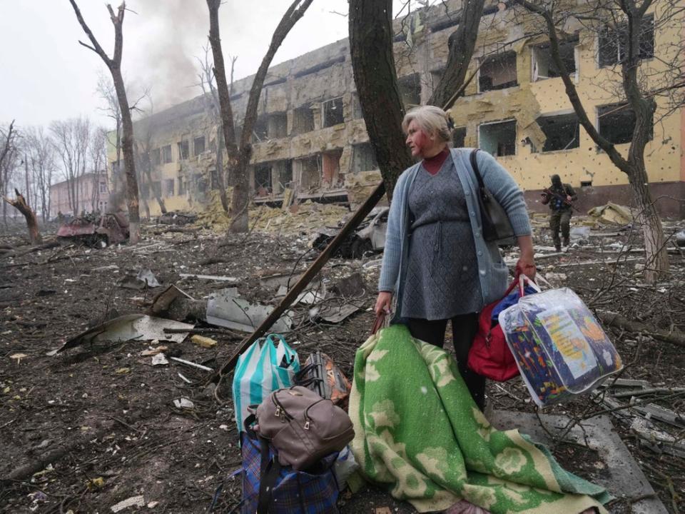 A woman walks outside a maternity hospital damaged by shelling in Mariupol (AP)
