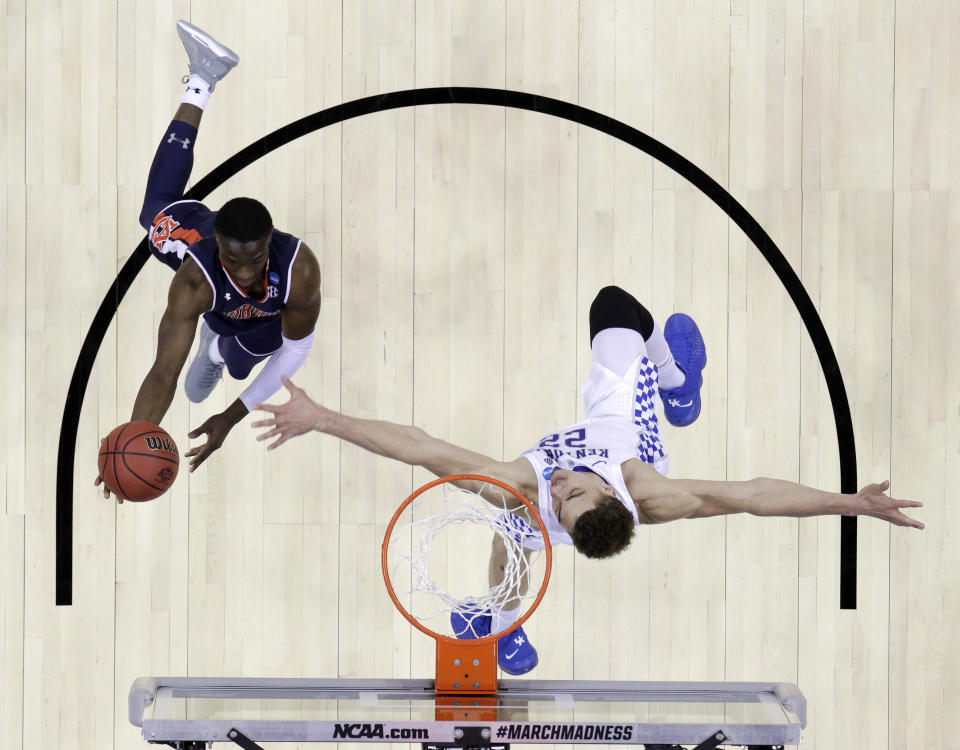 Auburn's Jared Harper, left, drives to the basket past Kentucky's Reid Travis during the first half of the Midwest Regional final game in the NCAA men's college basketball tournament Sunday, March 31, 2019, in Kansas City, Mo. (AP Photo/Charlie Riedel)