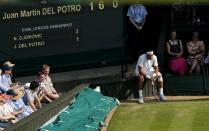 Argentina's Juan Martin Del Potro sits near the score board in his match against Serbia's Novak Djokovic during day eleven of the Wimbledon Championships at The All England Lawn Tennis and Croquet Club, Wimbledon.