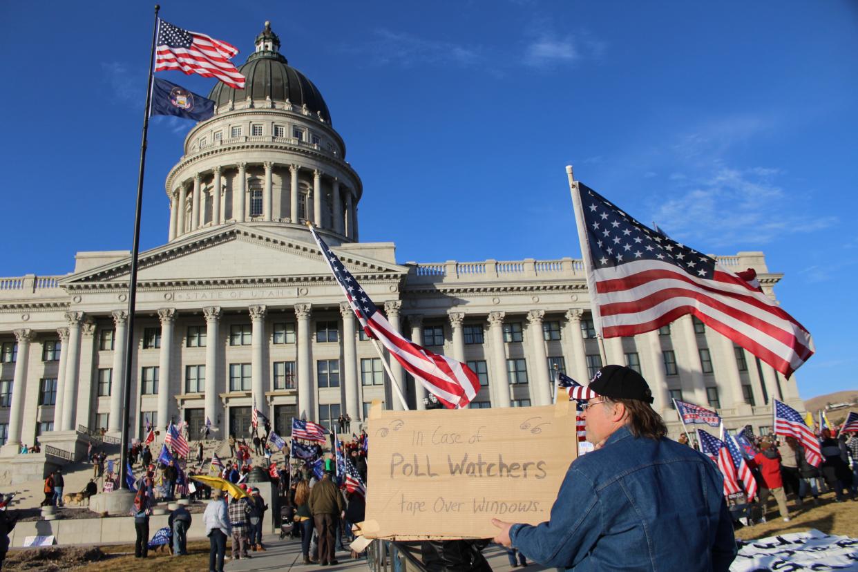 An attendee to Salt Lake City’s “Save America” rally holds up a sign in front of the Utah Capitol with the message “In case of poll watchers, tape over windows” on Wednesday, Jan. 6, 2021. (Enrique Limón)