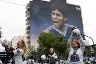 Women play with balls during the inauguration of a mural of Diego Maradona by artist Martin Ron in Buenos Aires, Argentina, Sunday, Oct. 30, 2022. Sunday marks the birth date of Maradona who died on Nov. 25, 2020 at the age of 60.(AP Photo/Rodrigo Abd)