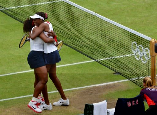 Venus (right) and Serena Williams celebrate after winning the women's doubles final. The sisters became the first tennis players to win four Olympic golds on Sunday after a 6-4, 6-4 victory over Czech pair Andrea Hlavackova and Lucie Hradecka in the women's doubles final at Wimbledon