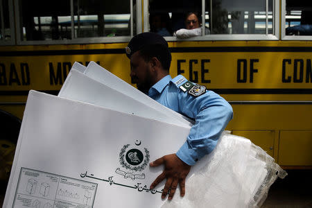 A police officer carries election materials at a distribution centre ahead of general election in Islamabad, Pakistan, July 24, 2018. REUTERS/Athit Perawongmetha