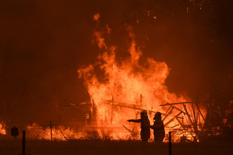 A firefighter is dead after a truck rolled over near Jingellic, east of Albury. Pictured are NSW Rural Fire Service crews fight the Gospers Mountain Fire as it impacts a structure at Bilpin. 