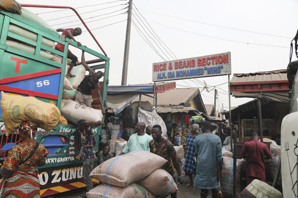 Workers offload grains from a truck at the Mile 12 Market in Lagos, Nigeria, Friday, Feb. 16, 2024. Nigerians are facing one of the West African nation's worst economic crises in as many years triggered by a surging inflation rate which follows monetary policies that have dipped the local currency to an all-time low against the dollar, provoking anger and protests across the country. (AP Photo/Mansur Ibrahim)