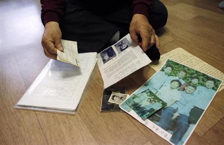 Jang Choon, who has been selected as one of 82 participants of a reunion ceremony this Thursday, looks at photographs and letters of his family in North Korea that he received via broker at his house in Namyangju, east of Seoul February 19, 2014. REUTERS/Kim Hong-Ji