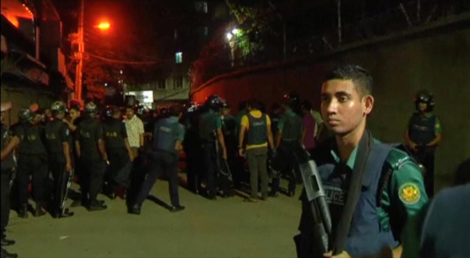 Members of the rapid action police battalion stand outside a house in Dhaka