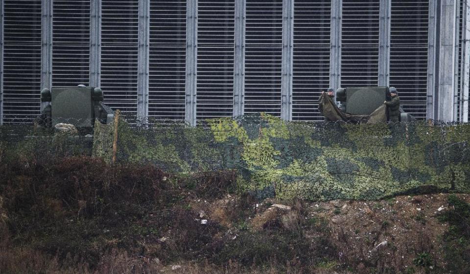 Russian soldiers fold a tarp in front of Tor-M1 air defense missile systems overlooking the Olympic Park ahead of the 2014 Winter Olympics, Wednesday, Jan. 29, 2014, in Sochi, Russia. The deployment of missiles is part of sweeping security measures put in place for the Olympics. (AP Photo/Pavel Golovkin)