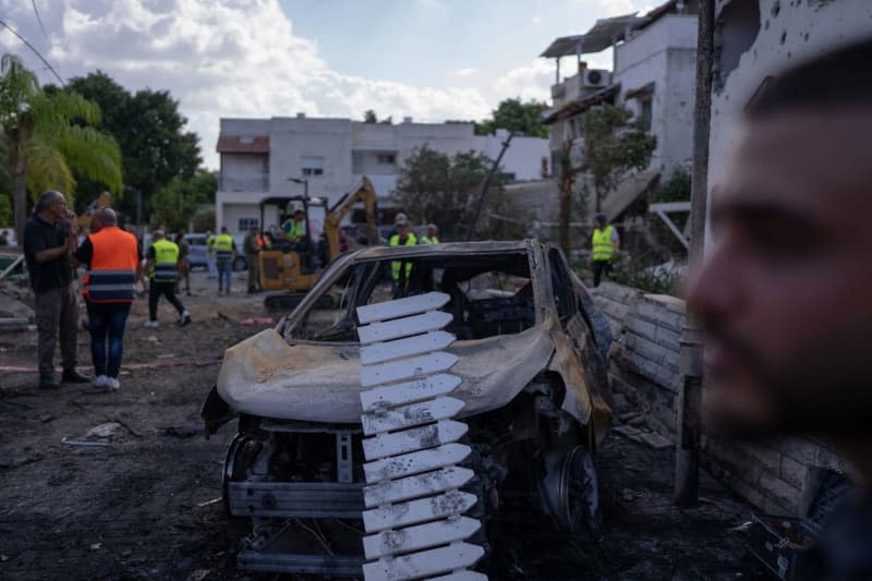 Security forces investigate a damaged vehicle in Kiryat Bialik following a reported strike by the pro-Iranian Hezbollah movement. Ilia Yefimovich/dpa