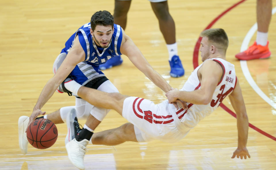 Wisconsin's Brad Davison (34) fouls Eastern Illinois' Josiah Wallace (22) during the first half of an NCAA college basketball game Wednesday, Nov. 25, 2020, in Madison, Wis. (AP Photo/Andy Manis)