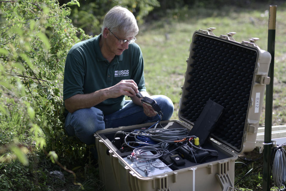 Thomas L. Pratt, a scientist with the United States Geological Survey, changes data cards in earthquake monitoring and recording equipment amid aftershocks across the island's southern coast where recent quakes have toppled homes and schools in Ponce, Puerto Rico, Tuesday, Jan. 14, 2020. The seismic activity that experts say is unusual but not unexpected has unleashed scientific debate about what’s causing it and drawn international attention to the area, where more than 4,000 people have sought shelter as they wonder when the ground will stop trembling. (AP Photo/Carlos Giusti)