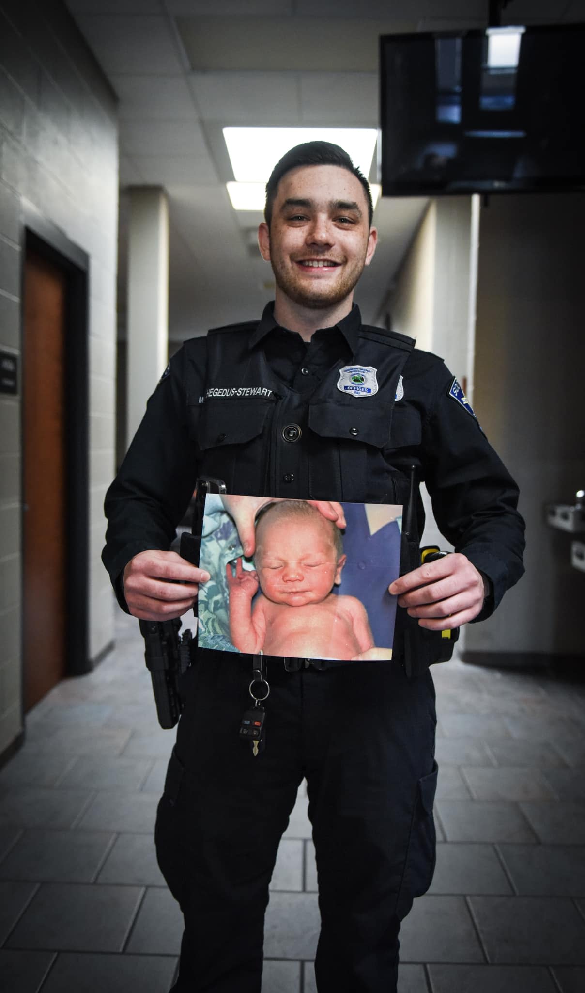South Bend Police Officer Matthew Hegedus-Stewart holding a photo of himself as an infant. 