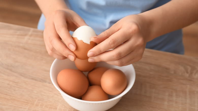 person peeling hard boiled eggs