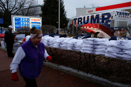 Vendors set up a stand to sell shirts and hats for the inauguration of U.S. President-elect Donald Trump at a gas station on Capitol Hill in Washington, U.S., January 19, 2017. REUTERS/Jonathan Ernst