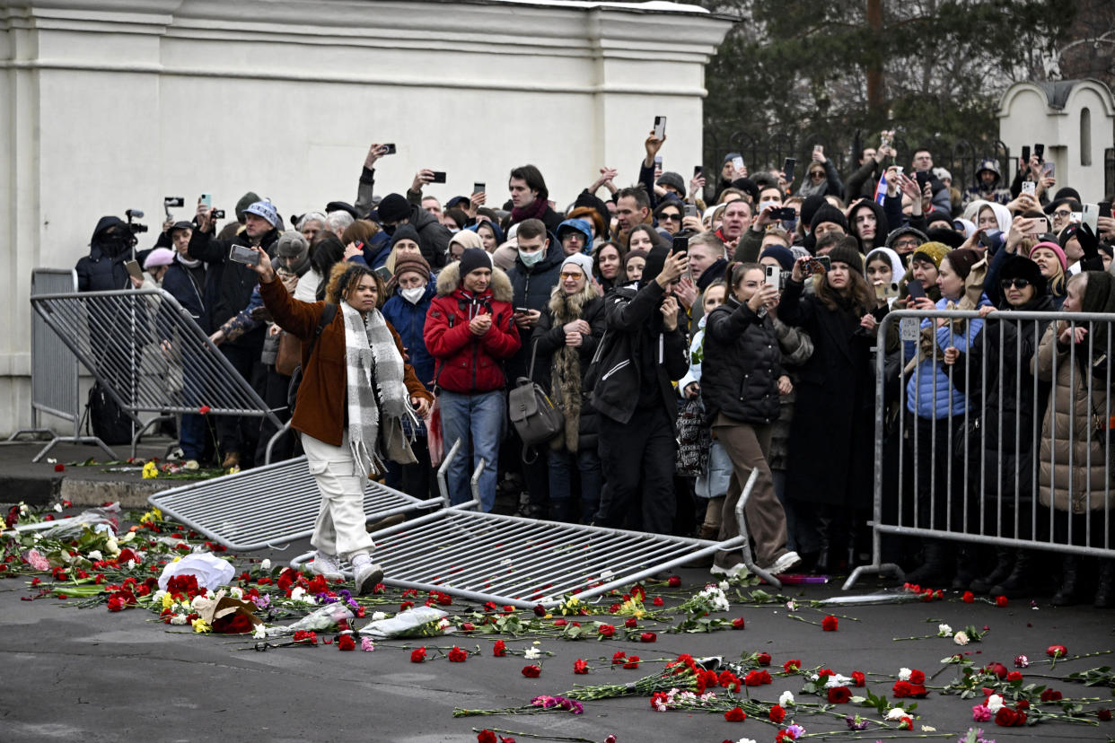 Mourners knock over a barrier outside the funeral.