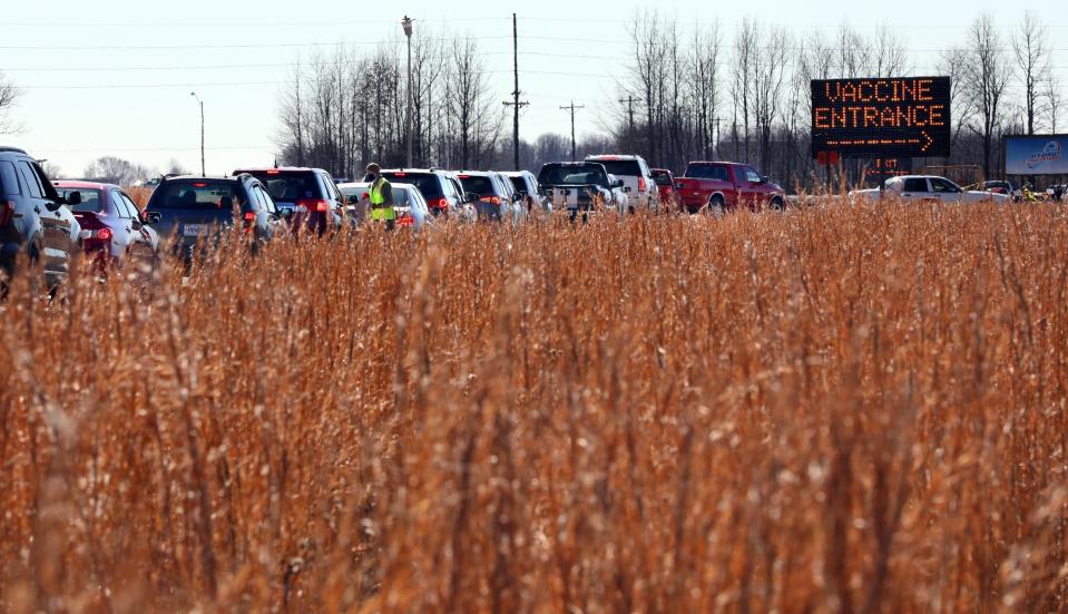 FILE - In this Jan. 22, 2021, file photo, vehicles snake through a line beside a farm field in Poplar Bluff, Mo., for the state's first mass COVID-19 vaccination event. As the unprecedented campaign to inoculate the most vulnerable Americans continues, those in some rural areas say they are getting slighted in favor of urban centers. (Robert Cohen/St. Louis Post-Dispatch via AP, File)