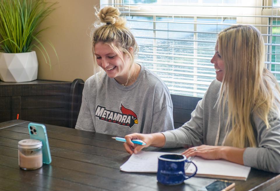 Metamora junior Kaidance Till, left, laughs while talking with a college softball recruiter during a Zoom chat at her Germantown Hills home. At right is her mother Heather.