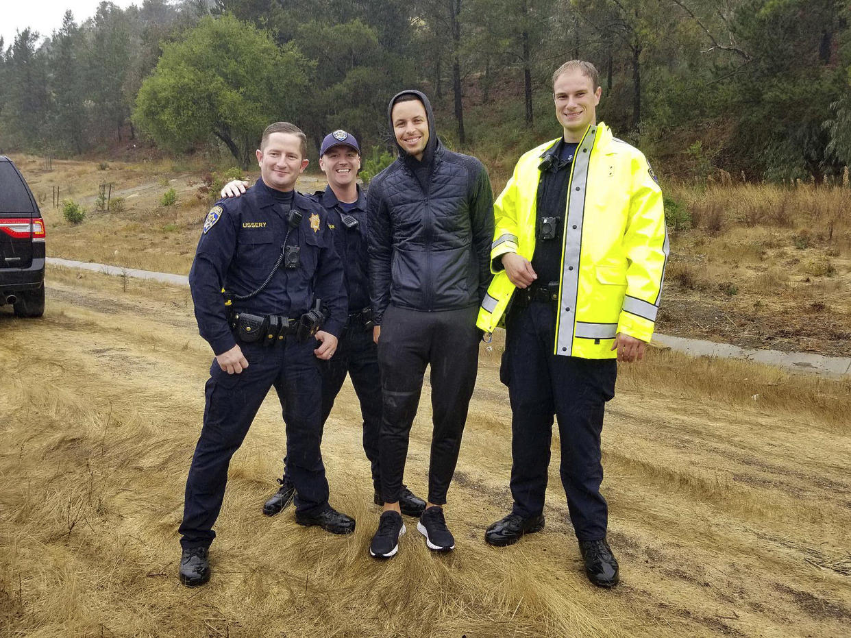 Stephen Curry, shown with California Highway Patrol officers, was not injured in a car crash last week. (California Highway Patrol Oakland via AP)