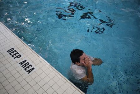 Raul Contreras, 19, of Honduras, who is seeking refugee status in Canada, works out at the pool of a long-stay hotel in Toronto, Ontario, Canada April 9, 2017. Picture taken April 9, 2017. REUTERS/Chris Helgren