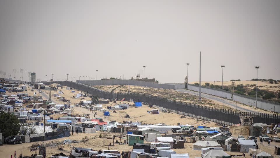 Palestinians displaced by the Israeli air and ground offensive on the Gaza Strip walk through a makeshift tent camp in Rafah on the border with Egypt, in Gaza on May 10. - Abdel Kareem Hana/AP