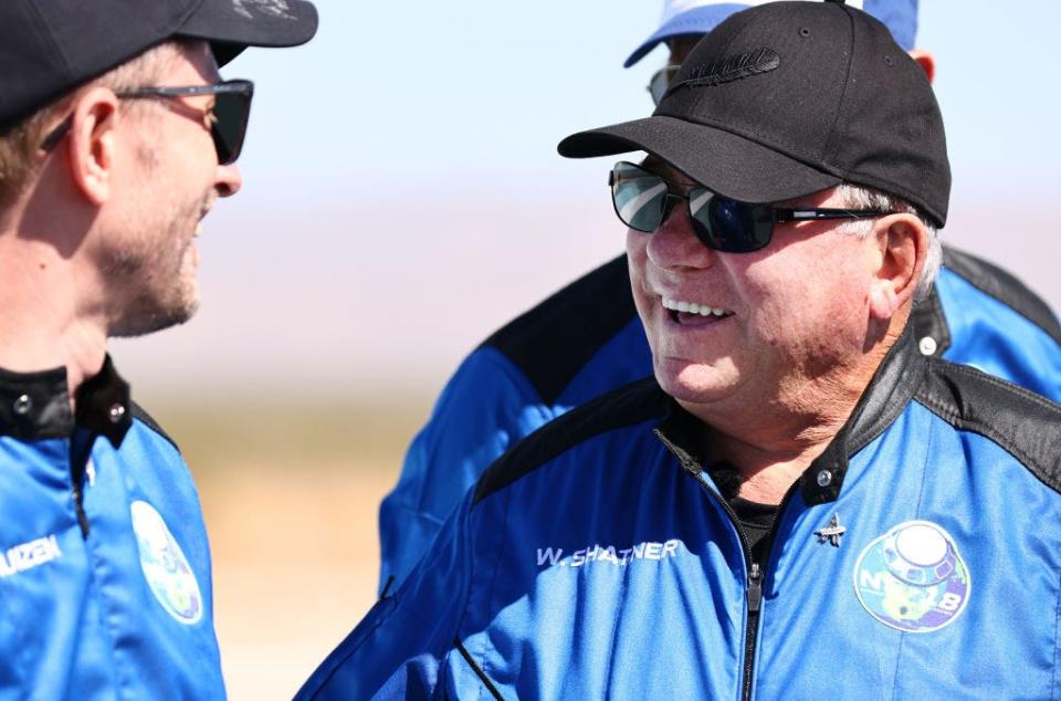 "Star Trek" actor William Shatner, right, smiles as Planet Labs co-founder Chris Boshuizen looks on during a media availability on the landing pad of Blue Origin's New Shepard after they flew into space on Oct. 13, 2021, near Van Horn, Texas. Shatner became the oldest person to fly into space on the 10-minute flight. They flew aboard mission NS-18, the second human spaceflight for the company, which is owned by Amazon founder Jeff Bezos.