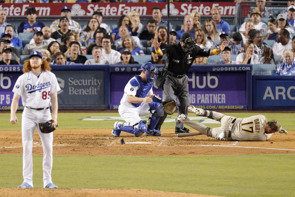 San Diego Padres' Brandon Drury, right, falls to the gournd after being hit in the helmet with a pitch thrown by Los Angeles Dodgers starting pitcher Dustin May, left, as catcher Will Smith, second from left, and home plate umpire Alfonso Marquez watch during the sixth inning of a baseball game Friday, Sept. 2, 2022, in Los Angeles. (AP Photo/Mark J. Terrill)