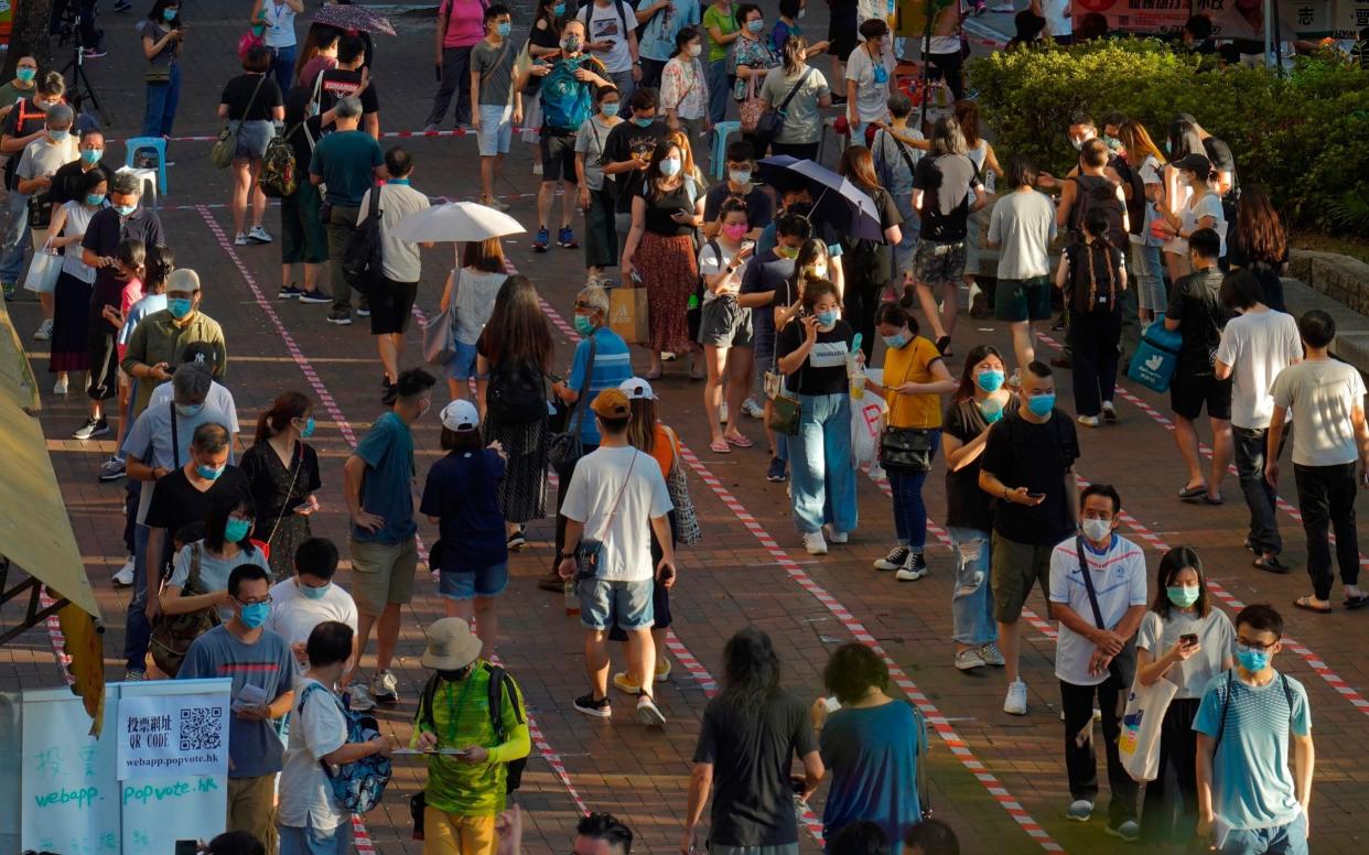 People queue up to vote in Hong Kong in an unofficial primary for pro-democracy candidates ahead of legislative elections in September - AP