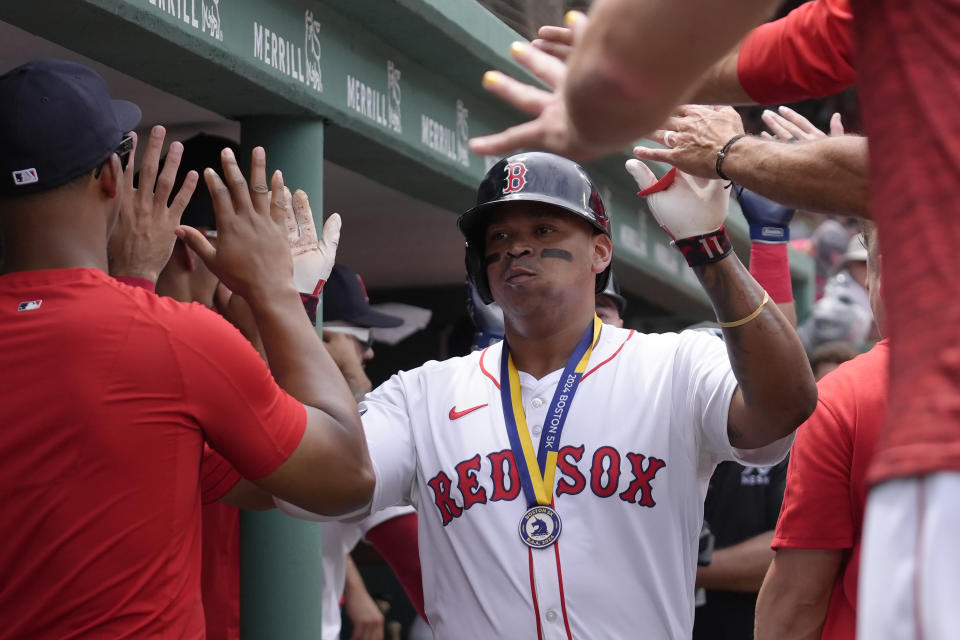 Boston Red Sox's Rafael Devers, center, celebrates with teammates in the dugout after scoring on his two-run home run in the first inning of a baseball game against the San Diego Padres, Sunday, June 30, 2024, in Boston. (AP Photo/Steven Senne)