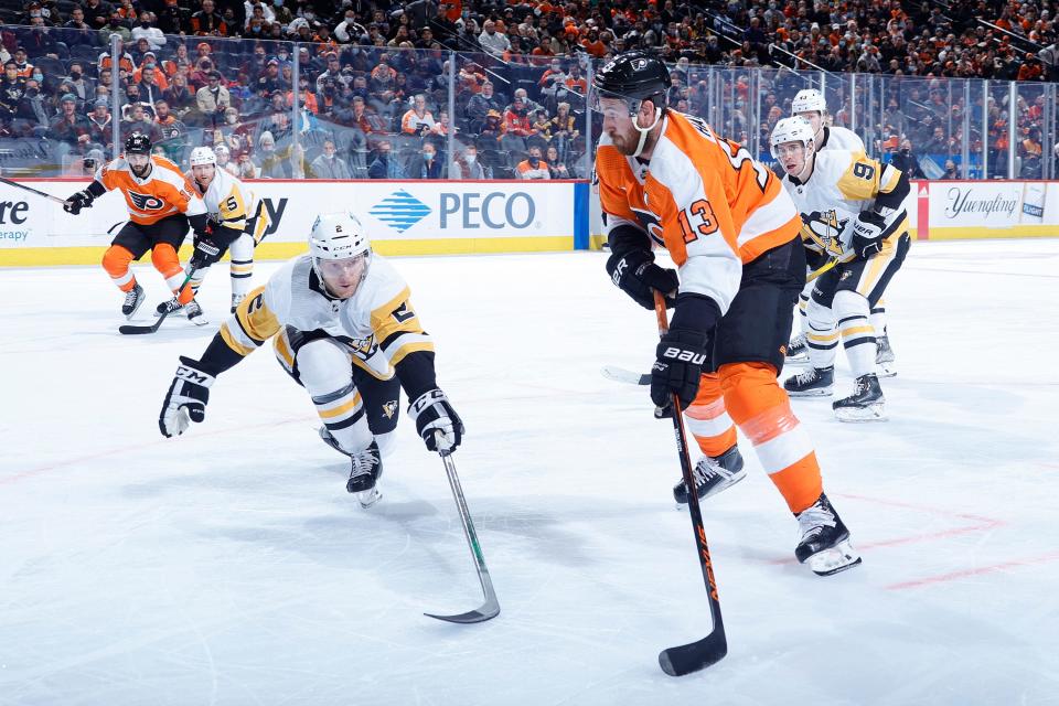 Kevin Hayes (13) of the Philadelphia Flyers is guarded by Chad Ruhwedel (2) of the Pittsburgh Penguins during the second period at Wells Fargo Center on Jan. 6, 2022, in Philadelphia.