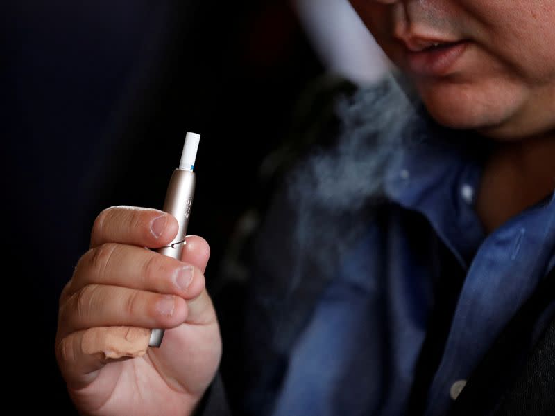 FILE PHOTO: A man tries Philip Morris' IQOS 3 device after its launching event in Tokyo