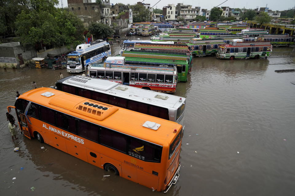Buses are parked in a flooded terminal caused by heavy monsoon rainfall in Lahore, Pakistan, Wednesday, July 5, 2023. Officials say heavy monsoon rains have lashed across Pakistan, killing a number of people. (AP Photo/K.M. Chaudary)