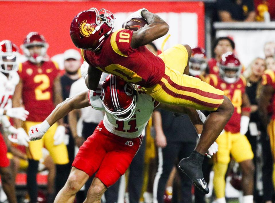 USC receiver Kyron Hudson makes a leaping catch over Utah safety R.J. Hubert during the Pac-12 championship game