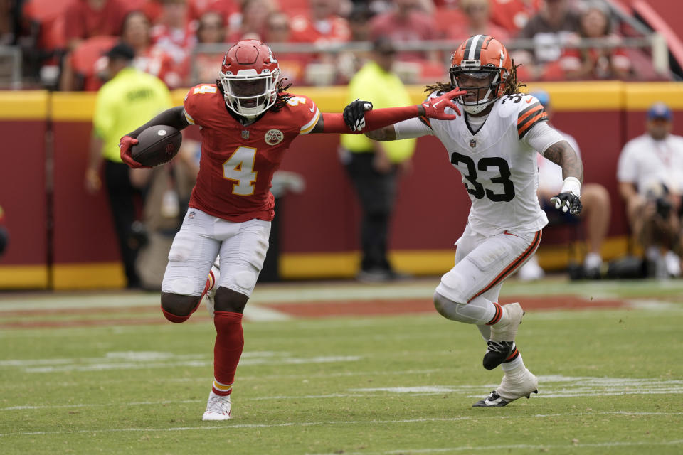 Kansas City Chiefs wide receiver Rashee Rice (4) runs with the ball past Cleveland Browns safety Ronnie Hickman (33) during the second half of an NFL preseason football game Saturday, Aug. 26, 2023, in Kansas City, Mo. (AP Photo/Charlie Riedel)