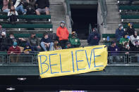 A "Believe" sign, similar to one seen in the TV series "Ted Lasso," hangs from outfield seats as fans look on during a baseball game between the Seattle Mariners and Oakland Athletics Monday, Sept. 27, 2021, in Seattle. (AP Photo/Elaine Thompson)